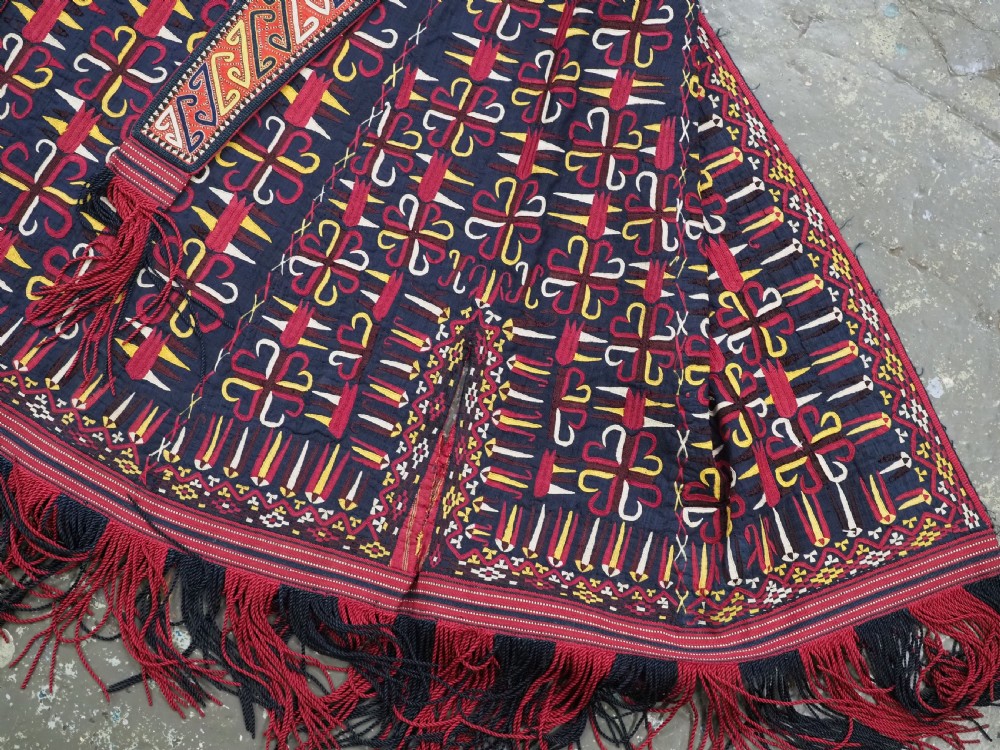 An antique 19th-century Turkmen chyrpy ceremonial coat featuring dense red, yellow, and white silk hand embroidery on a dark base with fringed borders. View VIII