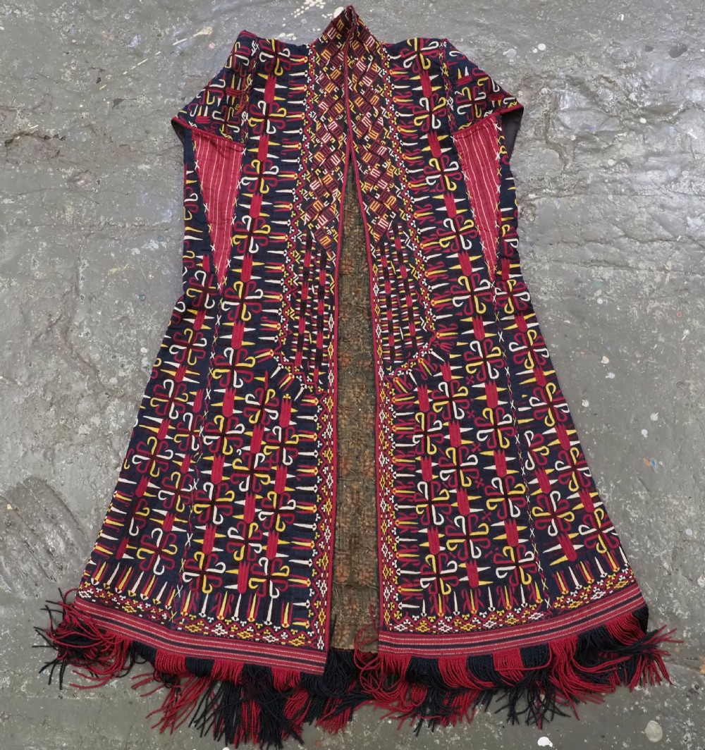 An antique 19th-century Turkmen chyrpy ceremonial coat featuring dense red, yellow, and white silk hand embroidery on a dark base with fringed borders. View IX