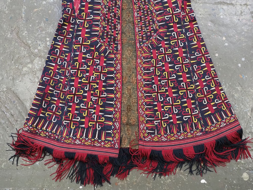 An antique 19th-century Turkmen chyrpy ceremonial coat featuring dense red, yellow, and white silk hand embroidery on a dark base with fringed borders. View XI