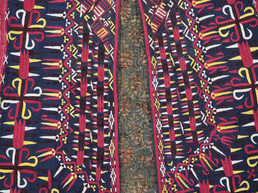 An antique 19th-century Turkmen chyrpy ceremonial coat featuring dense red, yellow, and white silk hand embroidery on a dark base with fringed borders. View XII