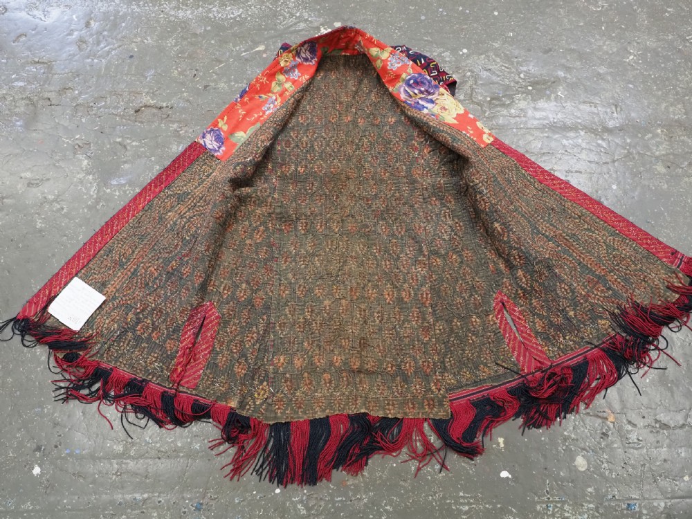 An antique 19th-century Turkmen chyrpy ceremonial coat featuring dense red, yellow, and white silk hand embroidery on a dark base with fringed borders. View XV