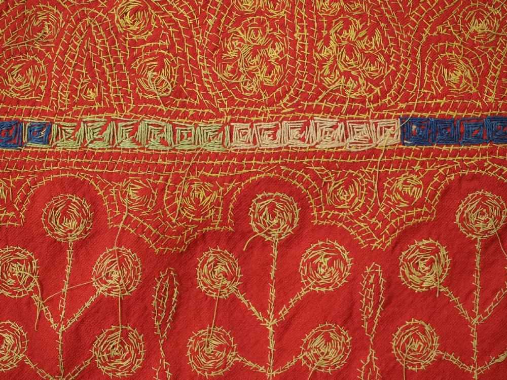 A rectangular red wool shawl with extensive gold-coloured needlework along the borders and corner motifs. View XVI