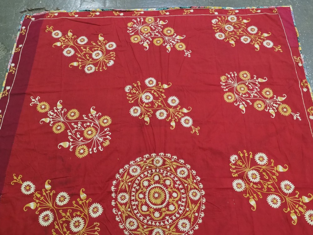 A rectangular red adras silk and cotton textile featuring yellow and white silk thread embroidery with a central circular floral medallion, surrounding floral sprays, and a matching decorative border. View II