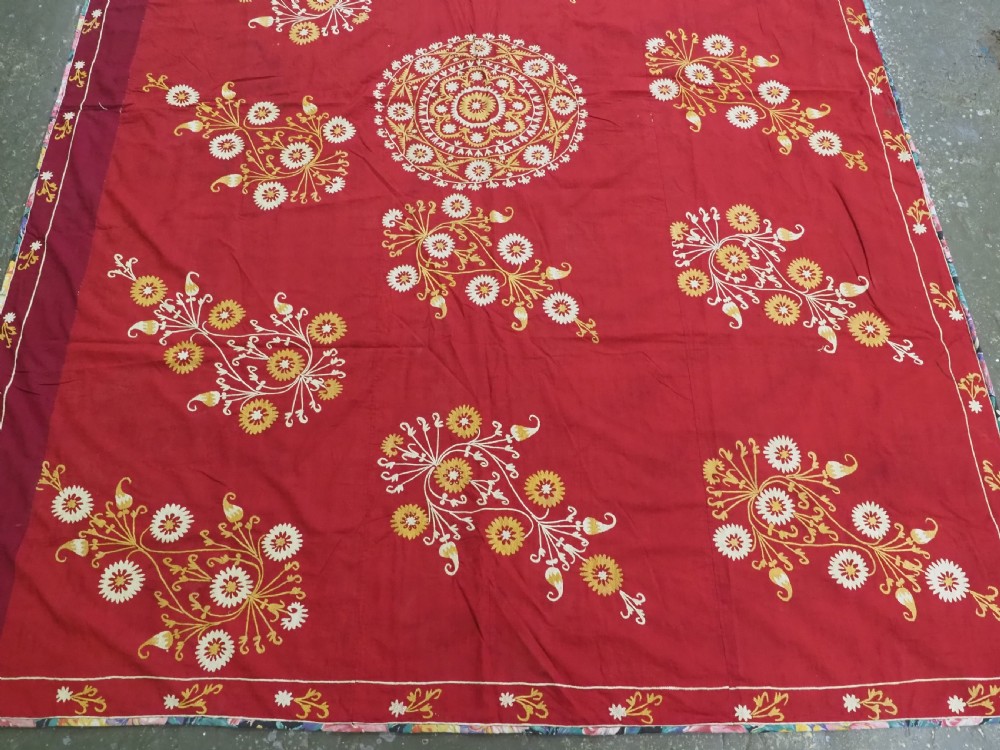 A rectangular red adras silk and cotton textile featuring yellow and white silk thread embroidery with a central circular floral medallion, surrounding floral sprays, and a matching decorative border. View IV