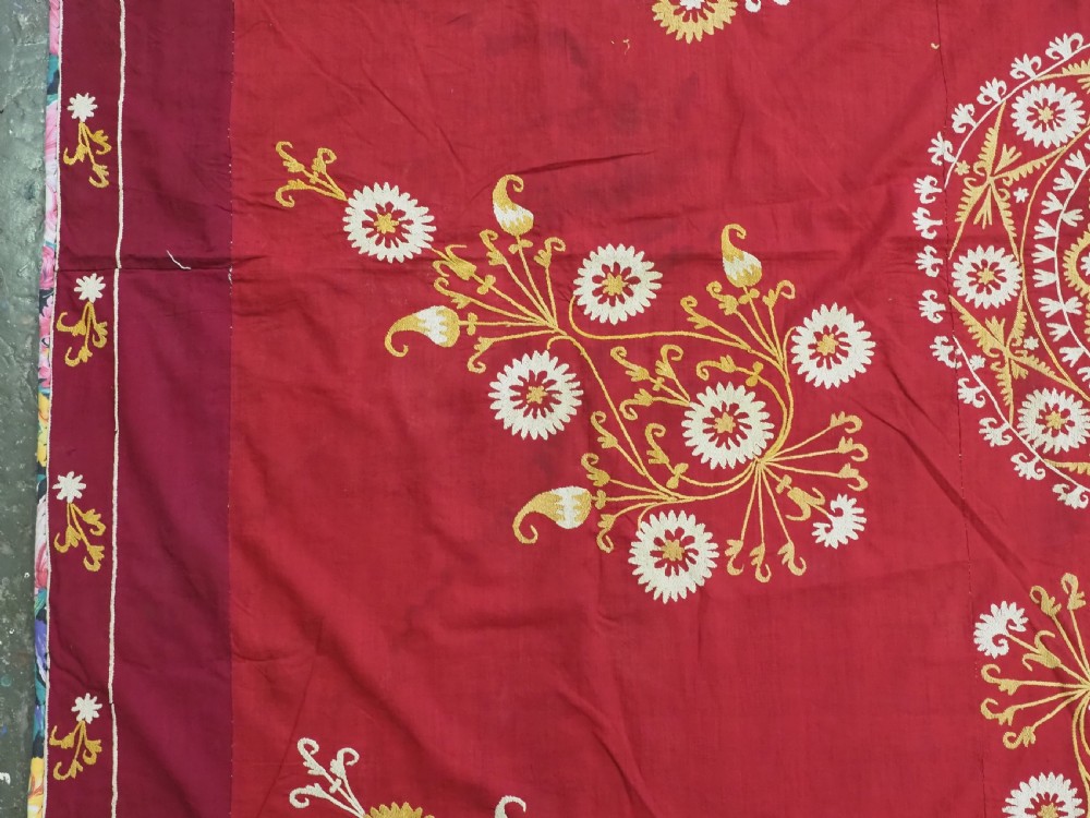 A rectangular red adras silk and cotton textile featuring yellow and white silk thread embroidery with a central circular floral medallion, surrounding floral sprays, and a matching decorative border. View VI