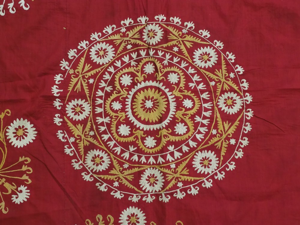 A rectangular red adras silk and cotton textile featuring yellow and white silk thread embroidery with a central circular floral medallion, surrounding floral sprays, and a matching decorative border. View VIII