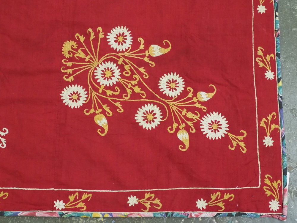 A rectangular red adras silk and cotton textile featuring yellow and white silk thread embroidery with a central circular floral medallion, surrounding floral sprays, and a matching decorative border. View X