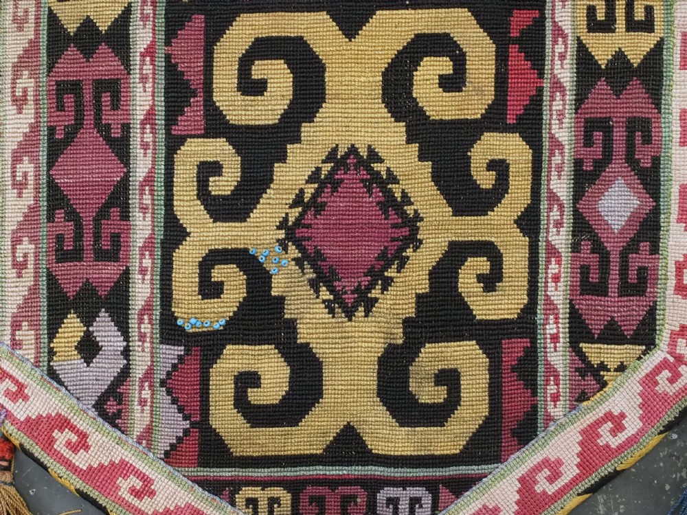 An antique Uzbek Lakai hand-embroidered wool textile featuring geometric horn motifs, a pointed lower hem, and multi-coloured yarn tassels. View VII