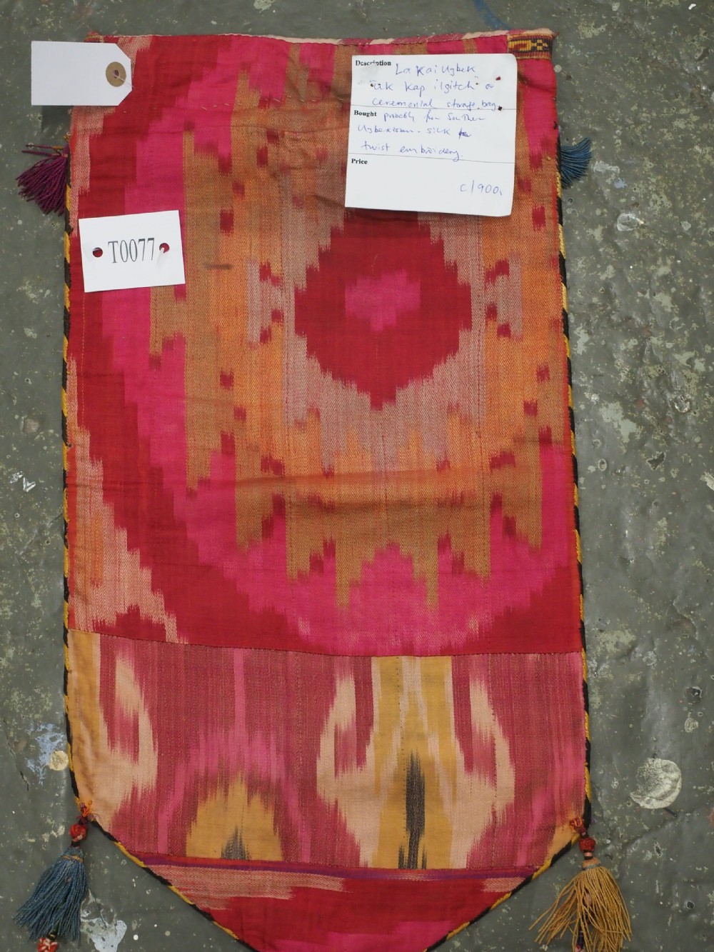 An antique Uzbek Lakai hand-embroidered wool textile featuring geometric horn motifs, a pointed lower hem, and multi-coloured yarn tassels. View IX