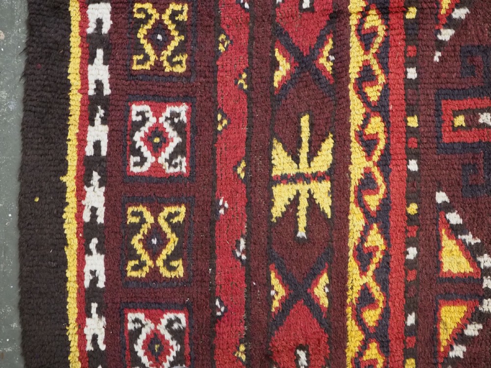 An antique handwoven Uzbek Julkyrs rug with geometric star motifs constructed from four vertical wool strips stitched together in tones of brown, red, and yellow. View IX