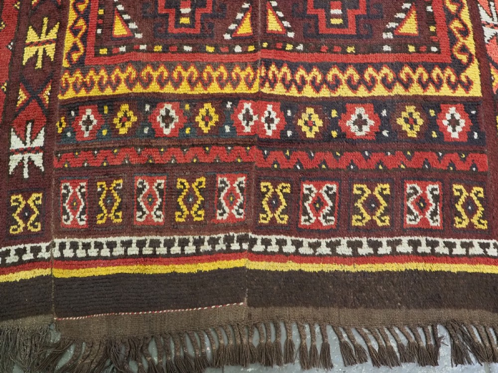 An antique handwoven Uzbek Julkyrs rug with geometric star motifs constructed from four vertical wool strips stitched together in tones of brown, red, and yellow. View XIII