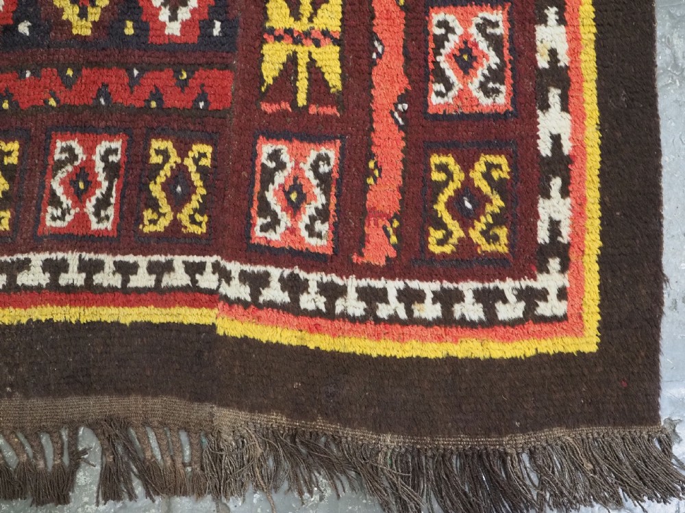 An antique handwoven Uzbek Julkyrs rug with geometric star motifs constructed from four vertical wool strips stitched together in tones of brown, red, and yellow. View XIV