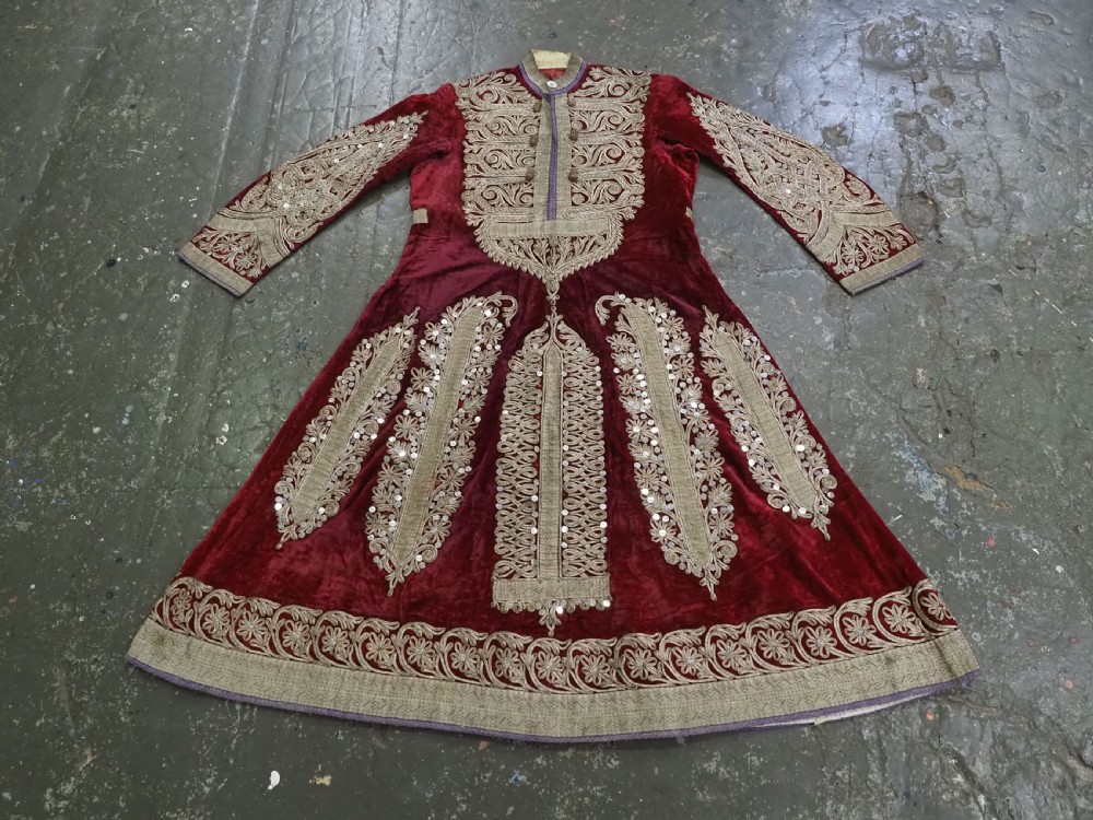 An antique late nineteenth-century Uzbek deep red velvet dress featuring heavy silver metal thread embroidery across the bodice, sleeves, and skirt. View II