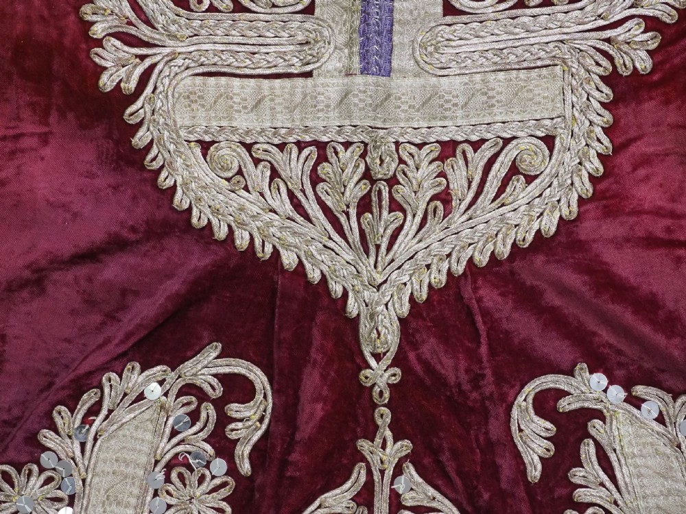 An antique late nineteenth-century Uzbek deep red velvet dress featuring heavy silver metal thread embroidery across the bodice, sleeves, and skirt. View VII
