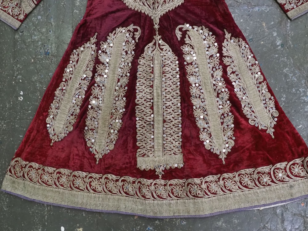 An antique late nineteenth-century Uzbek deep red velvet dress featuring heavy silver metal thread embroidery across the bodice, sleeves, and skirt. View VIII
