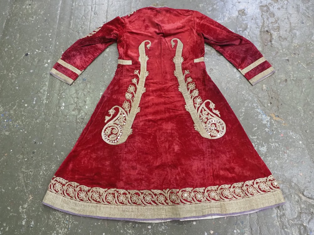 An antique late nineteenth-century Uzbek deep red velvet dress featuring heavy silver metal thread embroidery across the bodice, sleeves, and skirt. View XI