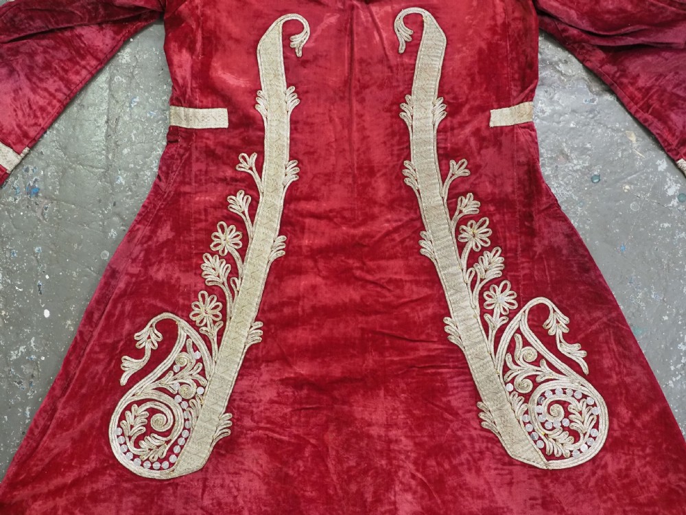 An antique late nineteenth-century Uzbek deep red velvet dress featuring heavy silver metal thread embroidery across the bodice, sleeves, and skirt. View XII