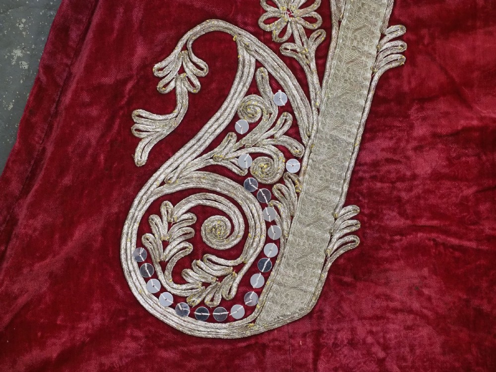An antique late nineteenth-century Uzbek deep red velvet dress featuring heavy silver metal thread embroidery across the bodice, sleeves, and skirt. View XIII