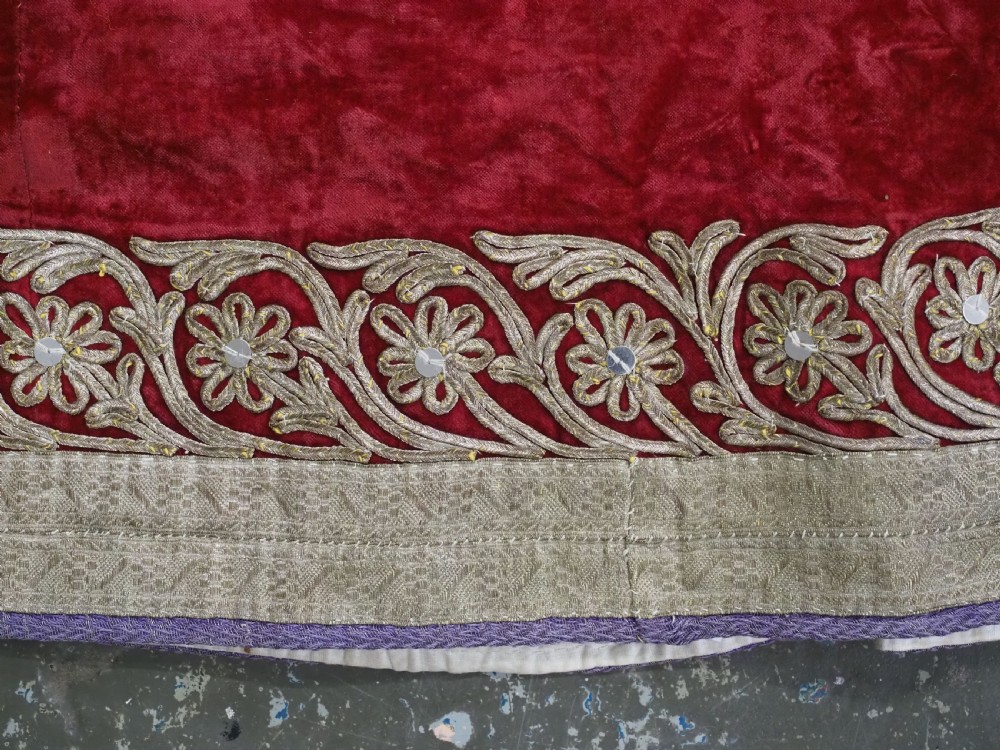 An antique late nineteenth-century Uzbek deep red velvet dress featuring heavy silver metal thread embroidery across the bodice, sleeves, and skirt. View XIV