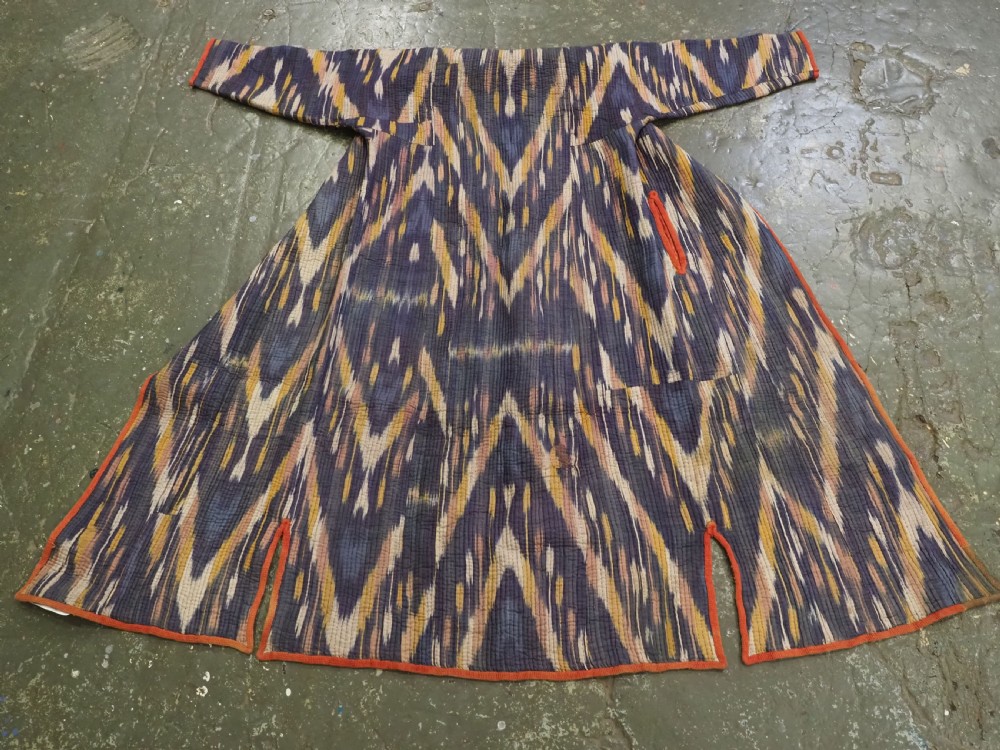 A quilted late 19th-century Uzbek silk ikat chapan coat featuring a bold chevron motif in indigo blue, yellow, and white, framed with red edge trimming. View II