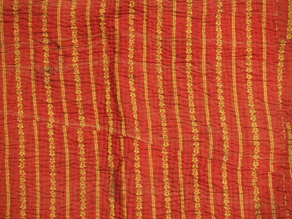 A quilted late 19th-century Uzbek silk ikat chapan coat featuring a bold chevron motif in indigo blue, yellow, and white, framed with red edge trimming. View X