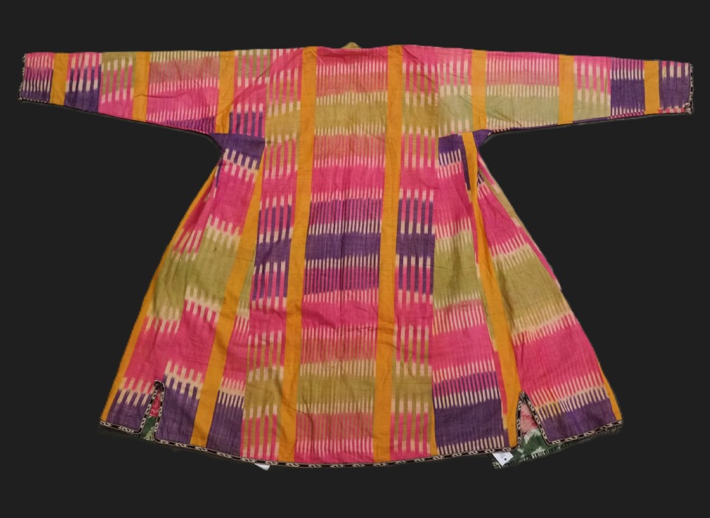 A late 19th-century Uzbek silk ikat khalat robe displaying pink, yellow, green, and purple vertical patterns.
