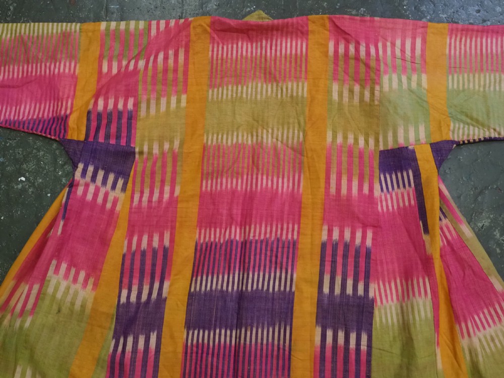 A late 19th-century Uzbek silk ikat khalat robe displaying pink, yellow, green, and purple vertical patterns. View V