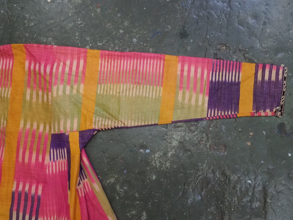 A late 19th-century Uzbek silk ikat khalat robe displaying pink, yellow, green, and purple vertical patterns. View VII