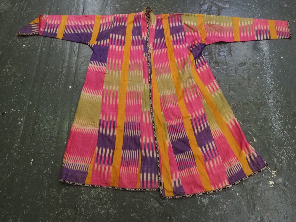 A late 19th-century Uzbek silk ikat khalat robe displaying pink, yellow, green, and purple vertical patterns. View IX