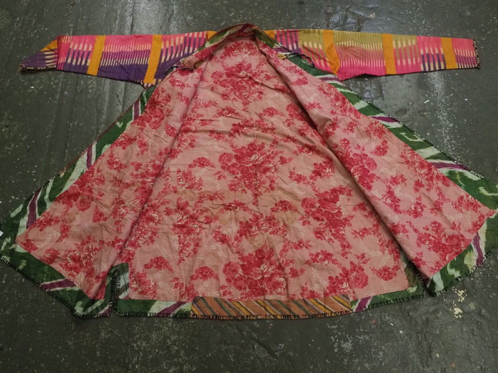 A late 19th-century Uzbek silk ikat khalat robe displaying pink, yellow, green, and purple vertical patterns. View X