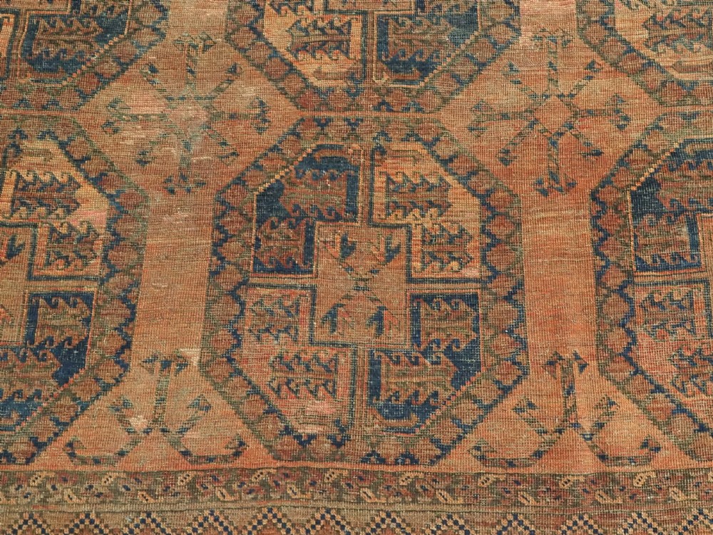 An antique hand-knotted wool carpet featuring repeating octagonal gul motifs on a terracotta background framed by geometric borders. View XI