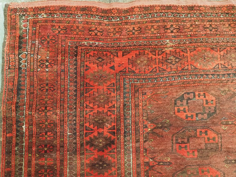 An antique Afghan Kizil Ayak Turkmen wool carpet featuring repeating octagonal gul motifs on a deep red field framed by geometric patterned borders. View VI