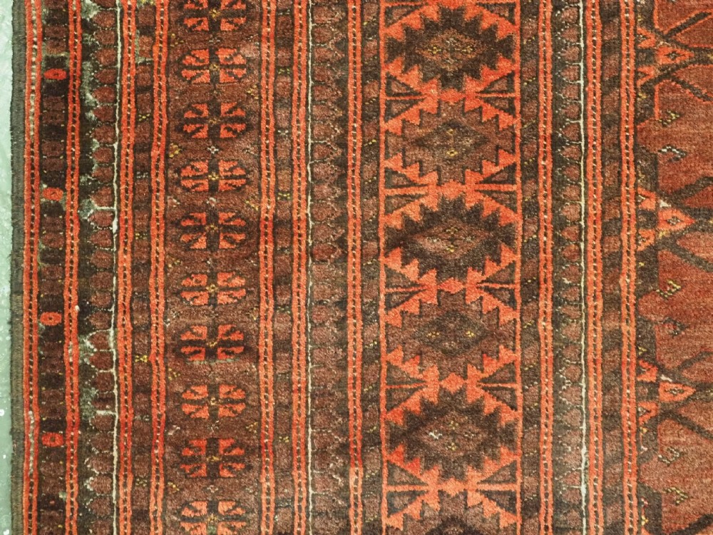 An antique Afghan Kizil Ayak Turkmen wool carpet featuring repeating octagonal gul motifs on a deep red field framed by geometric patterned borders. View VII