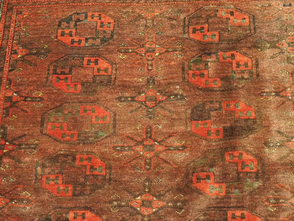 An antique Afghan Kizil Ayak Turkmen wool carpet featuring repeating octagonal gul motifs on a deep red field framed by geometric patterned borders. View VIII