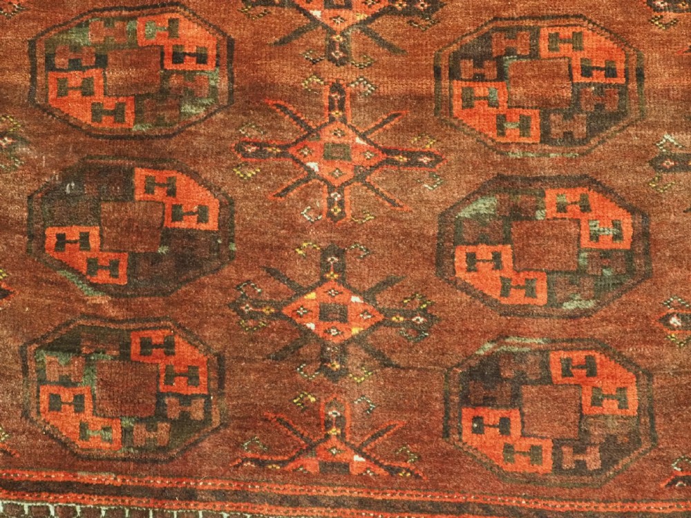 An antique Afghan Kizil Ayak Turkmen wool carpet featuring repeating octagonal gul motifs on a deep red field framed by geometric patterned borders. View XI