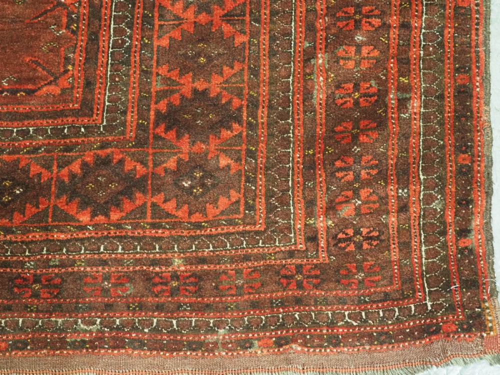 An antique Afghan Kizil Ayak Turkmen wool carpet featuring repeating octagonal gul motifs on a deep red field framed by geometric patterned borders. View XII