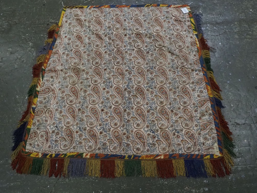 An early 20th-century Uzbek Lakai embroidered saddle cover featuring vibrant silk boteh and floral motifs on a grey ground with colourful fringe trim. View XV
