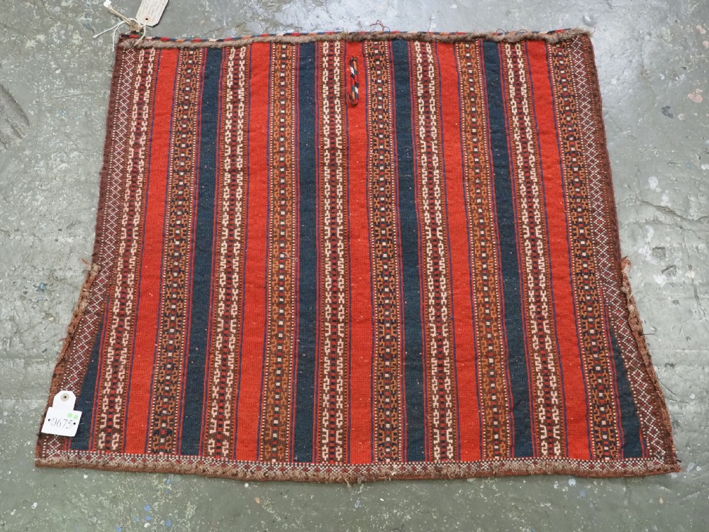 An antique square Turkmen Yomut saddle rug featuring vertical red and navy blue stripes with geometric tribal patterns and woven borders. View XI