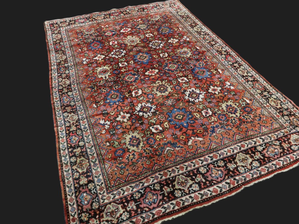 An antique Persian Mahal hand-knotted wool carpet featuring a red central field decorated with an all-over palmette motif and multi-tiered patterned borders. View II
