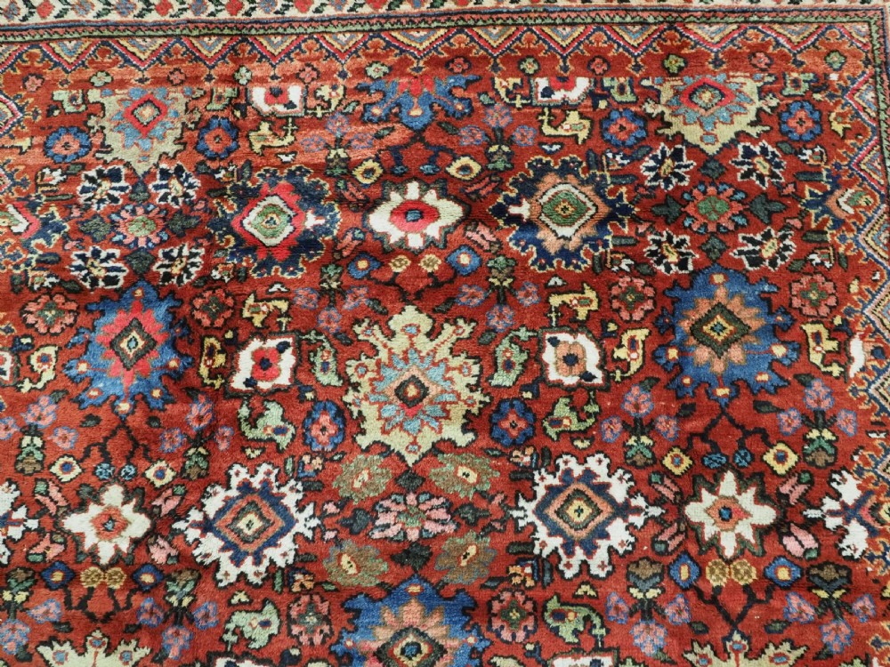 An antique Persian Mahal hand-knotted wool carpet featuring a red central field decorated with an all-over palmette motif and multi-tiered patterned borders. View VIII