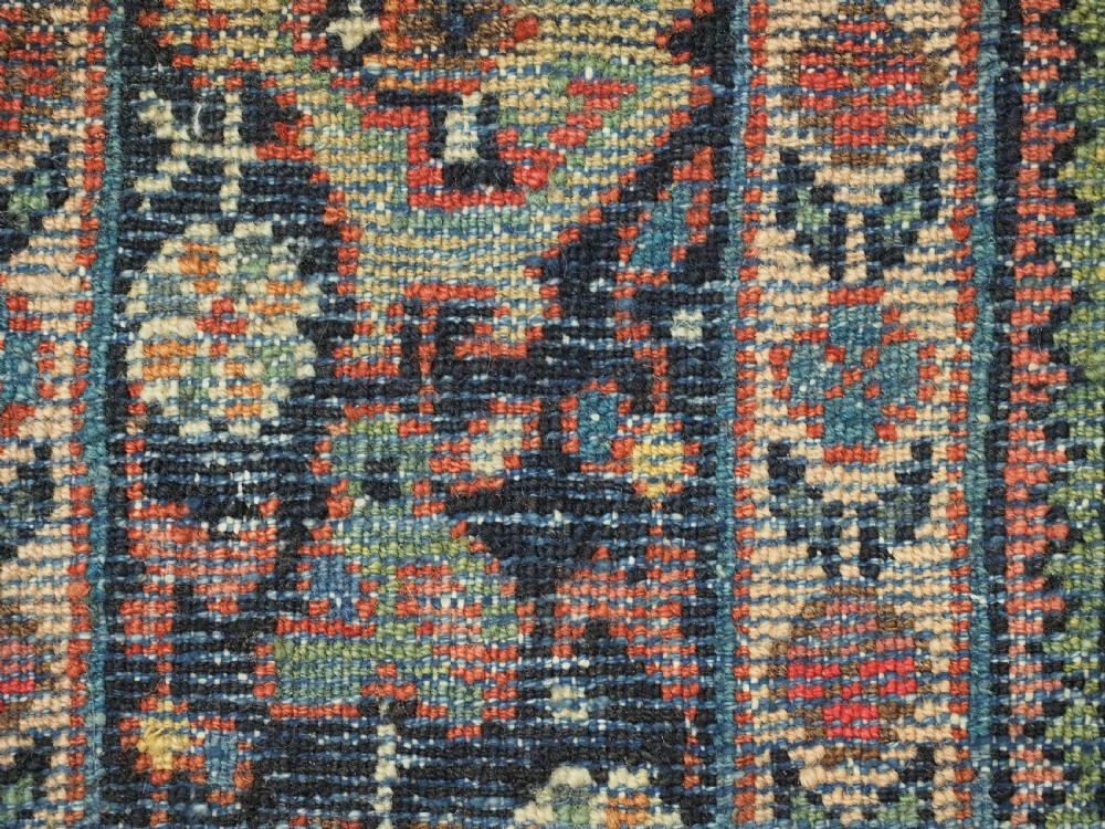 An antique Persian Mahal hand-knotted wool carpet featuring a red central field decorated with an all-over palmette motif and multi-tiered patterned borders. View XIII