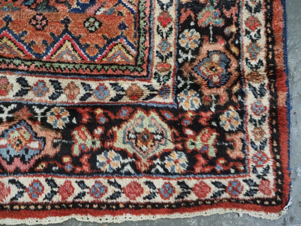 An antique Persian Mahal hand-knotted wool carpet featuring a red central field decorated with an all-over palmette motif and multi-tiered patterned borders. View XIV