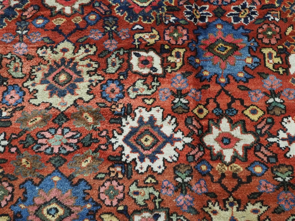 An antique Persian Mahal hand-knotted wool carpet featuring a red central field decorated with an all-over palmette motif and multi-tiered patterned borders. View XV