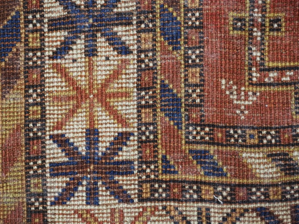 An antique hand-knotted Qashqai tribal rug featuring a central stepped diamond medallion in navy blue, red, and ivory surrounded by geometric peacock figures. View XV