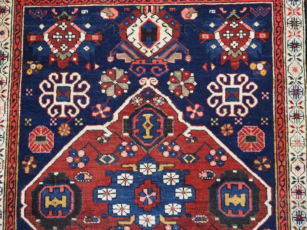 An antique hand-knotted Caucasian Alpan-Kuba runner rug featuring geometric diamond medallions in red and navy blue with detailed ivory borders. View XI