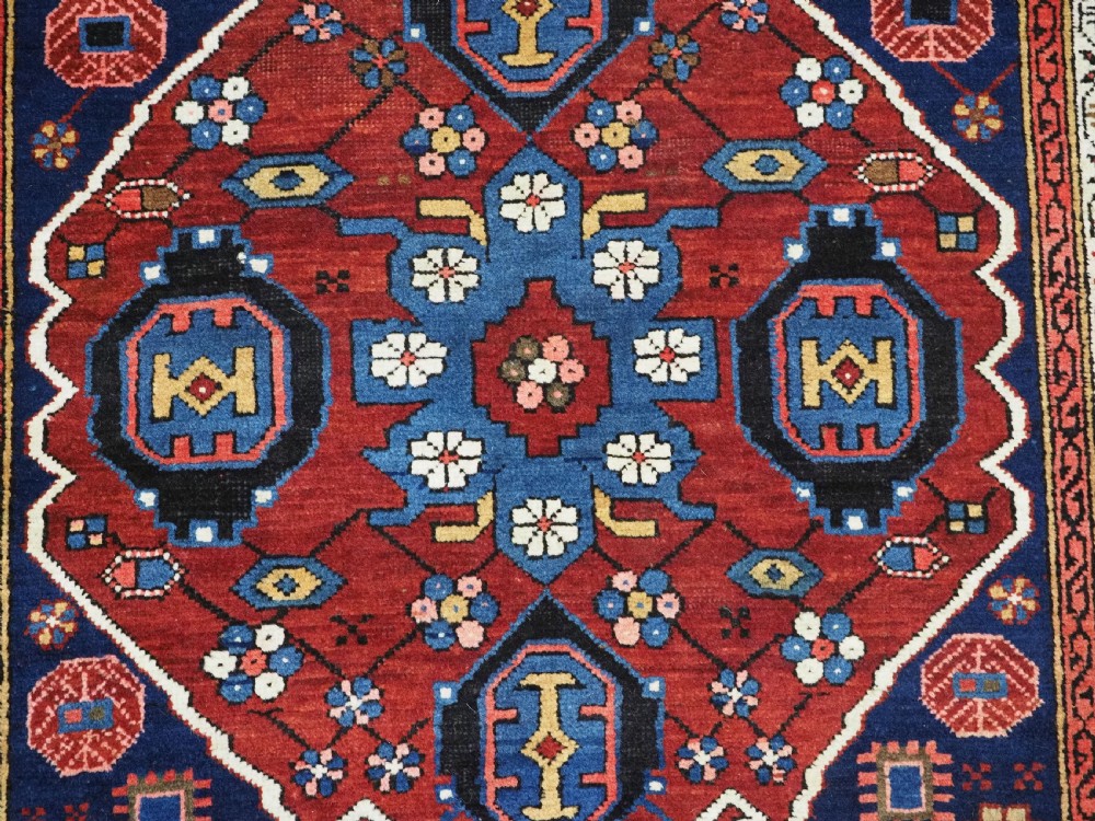 An antique hand-knotted Caucasian Alpan-Kuba runner rug featuring geometric diamond medallions in red and navy blue with detailed ivory borders. View XIV