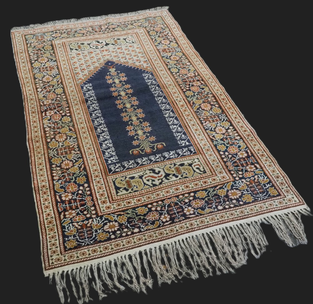 An antique Turkish Panderma hand-knotted wool prayer rug featuring a navy central niche with a floral motif surrounded by detailed ivory and rust geometric floral borders. View II