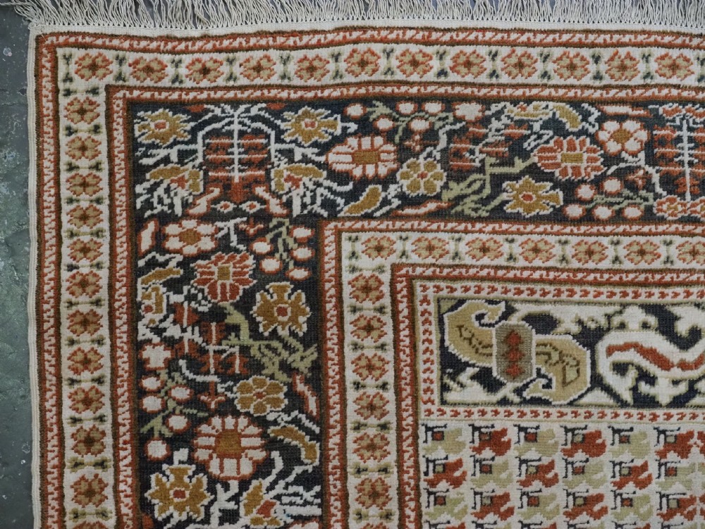 An antique Turkish Panderma hand-knotted wool prayer rug featuring a navy central niche with a floral motif surrounded by detailed ivory and rust geometric floral borders. View VIII