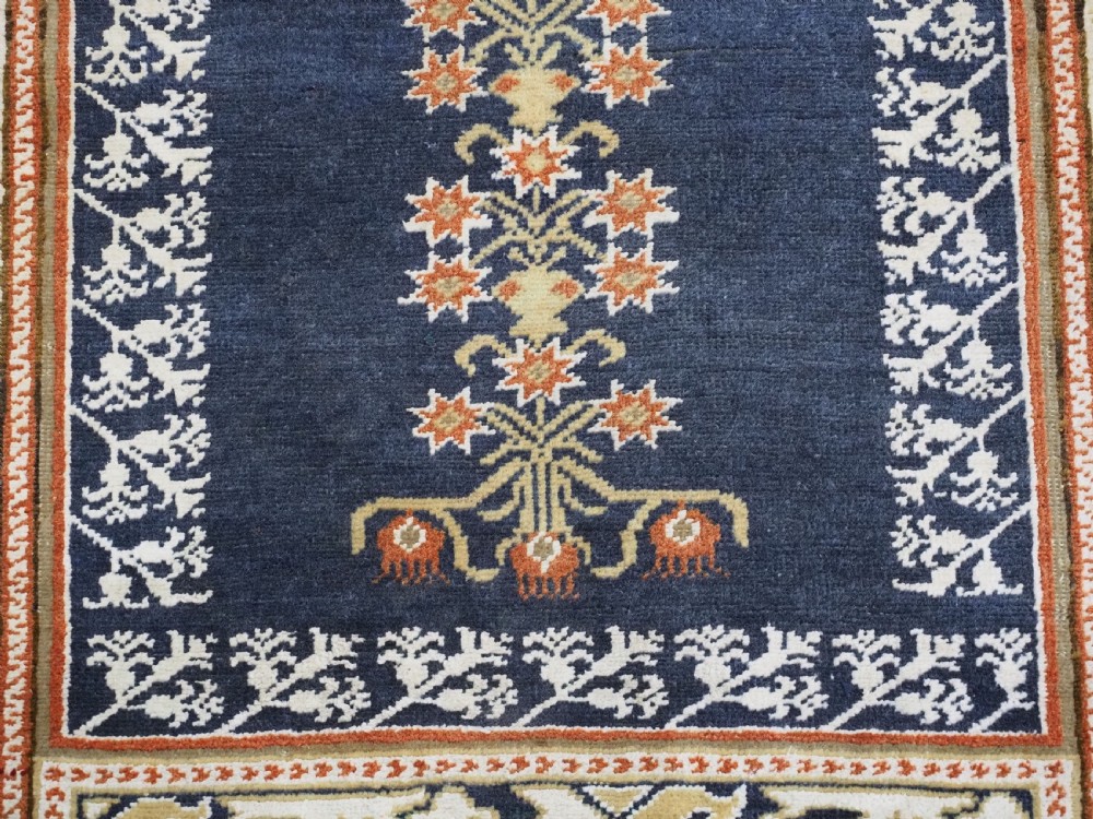An antique Turkish Panderma hand-knotted wool prayer rug featuring a navy central niche with a floral motif surrounded by detailed ivory and rust geometric floral borders. View XI