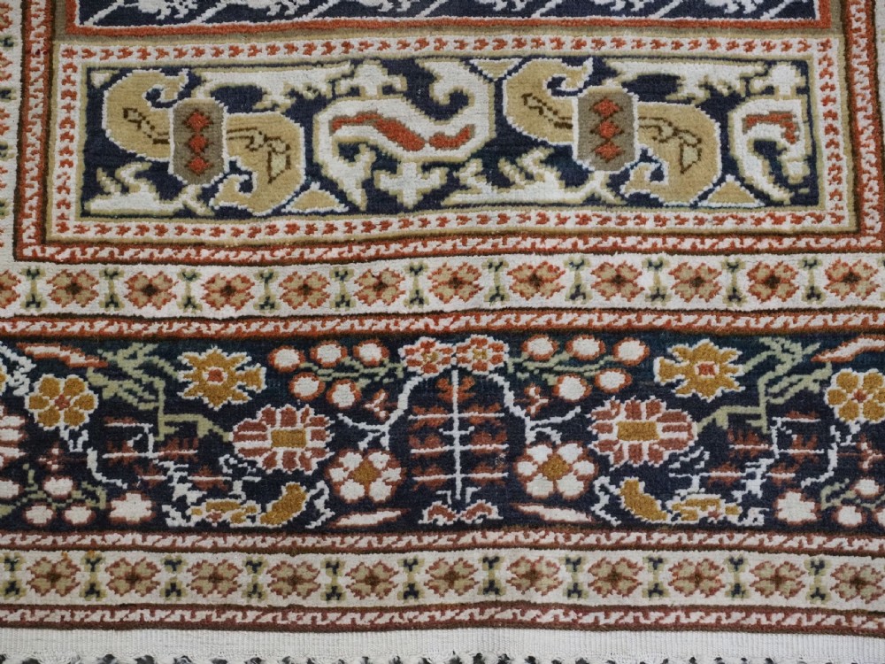 An antique Turkish Panderma hand-knotted wool prayer rug featuring a navy central niche with a floral motif surrounded by detailed ivory and rust geometric floral borders. View XII